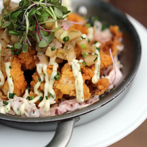 fried oysters on a bed of slaw topped with chutney and greens